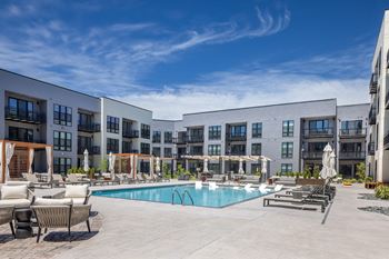 Resort-style interior courtyard with pool, cabanas, bocce ball, putting greens, fire tables, and outdoor kitchen